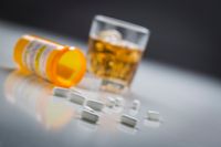Prescription-Drugs-Spilled-From-Fallen-Bottle-Near-Glass-of-Alcohol-524541546_5760x3840